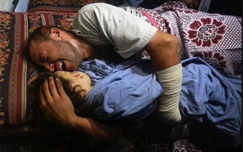 تصویر وداع پدر فلسطینی با دختر دو ساله شهیدش در شبکه‌های اجتماعی